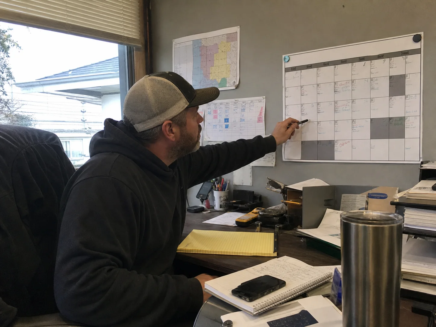 Home service business owner planning seasonal work with a calendar and crew schedule